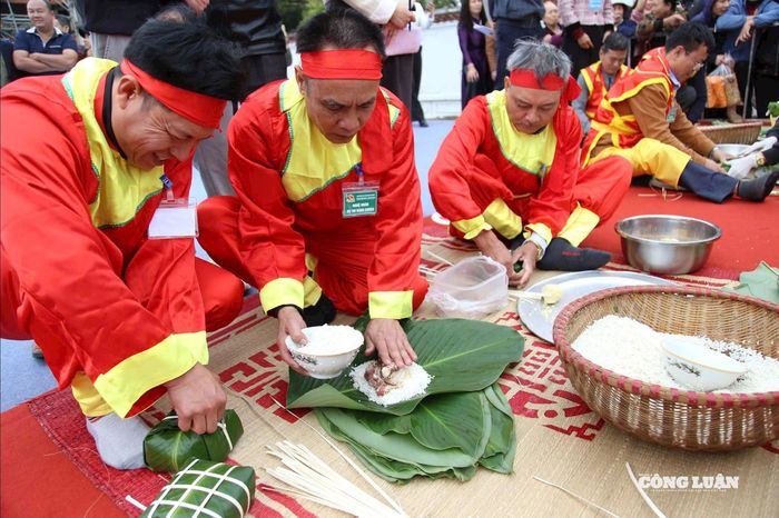 Những đôi bàn tay vốn quen với việc đồng áng nay bỗng trở nên mềm mại, thoăn thoắt xếp lá dong, rải gạo nếp cái hoa vàng, đặt nhân đậu xanh thịt mỡ một cách vuông vức. Chỉ trong vòng 45 phút, hàng trăm chiếc bánh chưng xanh mướt đã được hoàn thành, đều tăm tắp như khuôn đúc, thể hiện sự tỉ mỉ và tâm huyết của người làm. Ảnh BTC.