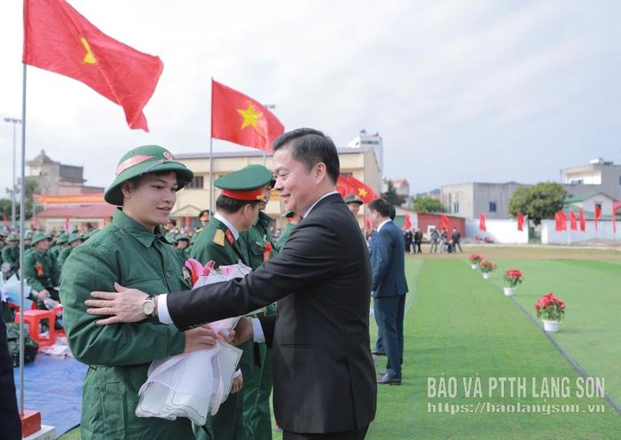 Đồng chí Đinh Hữu Học, Ủy viên Ban Thường vụ Tỉnh ủy, Phó Chủ tịch Thường trực UBND tỉnh tặng hoa động viên tân binh