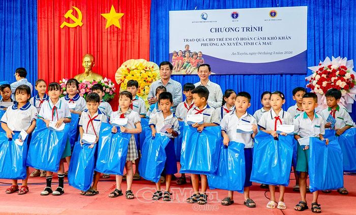 Thứ trưởng Bộ Y tế - PGS, TS, BSCKII. Nguyễn Tri Thức và lãnh đạo Sở Y tế tỉnh Cà Mau trao quà cho các em học sinh có hoàn cảnh khó khăn.