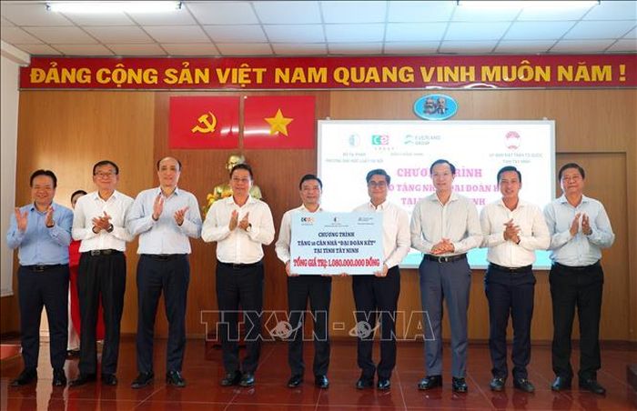 Lãnh đạo Trường Đại học Luật Hà Nội cùng đại diện các đơn vị đồng hành trao bảng tượng trưng hỗ trợ nguồn lực xây dựng 18 căn “Nhà Đại đoàn kết” cho người dân Tây Ninh.