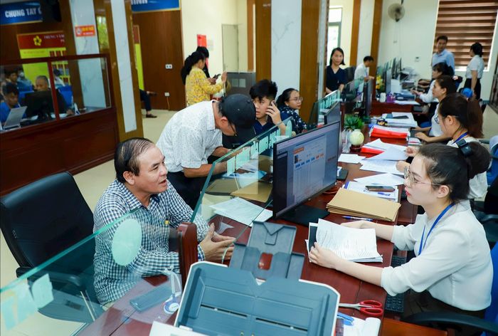Cán bộ Trung tâm Phục vụ hành chính công phường Thành Vinh trao đổi, hướng dẫn công dân làm thủ tục chuyển đổi giấy chứng nhận quyền sử dụng đất từ bìa đỏ sang bìa hồng. Ảnh tư liệu minh họa: Thành Duy