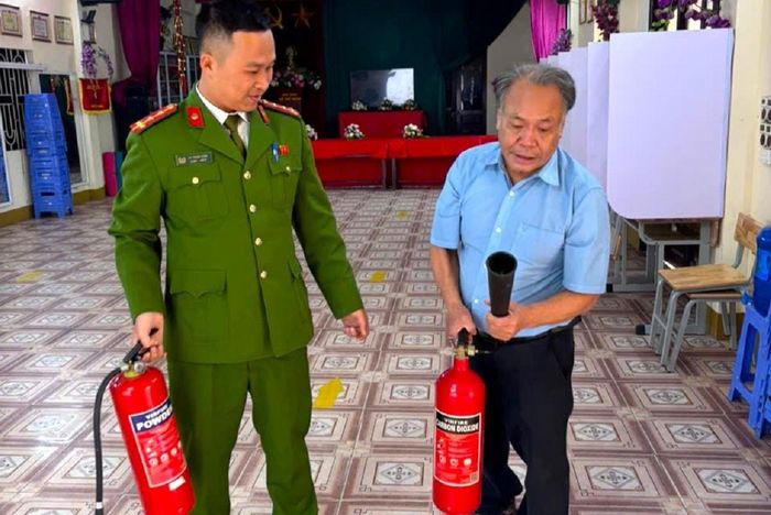 Cán bộ Đội Chữa cháy và cứu nạn, cứu hộ khu vực số hướng dẫn thành viên tổ bầu cử tại xã Thanh Trì sử dụng bình chữa cháy. Ảnh: VT