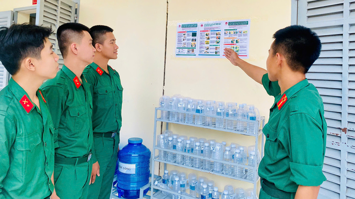 Tiểu đội trưởng giới thiệu cho chiến sĩ mới những quy định của đơn vị.