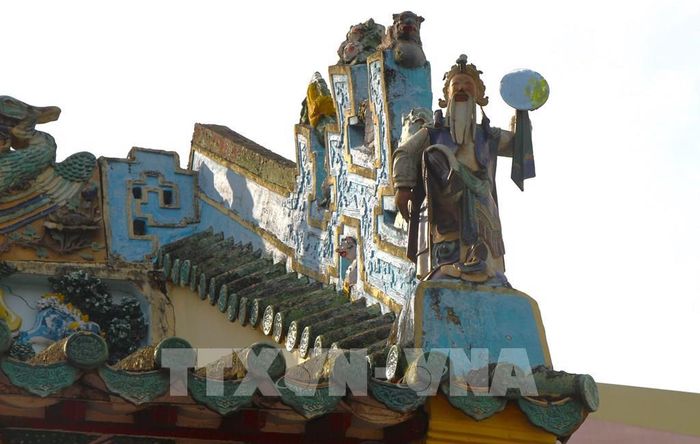 Phần mái, ngoài các biểu tượng long phụng, còn có tượng Ông Nhật, Bà Nguyệt tượng trưng cho âm - dương trong văn hóa Á Đông. Ảnh: Nguyễn Hằng - TTXVN