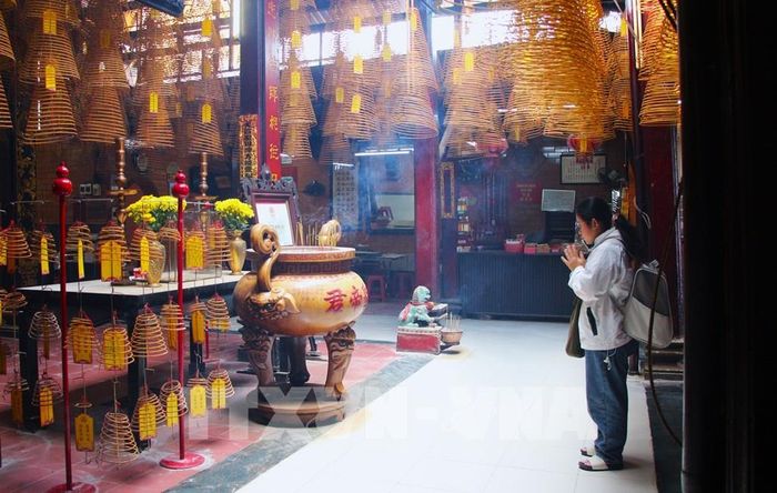 Hình thức cầu an, cầu phúc phổ biến nhất ở chùa Ông là cúng nhang khoanh. Ảnh: Nguyễn Hằng - TTXVN
