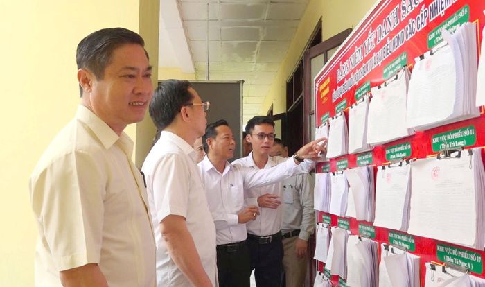 Phó Chủ tịch UBND thành phố Phan Thái Bình (bên trái) kiểm tra công tác chuẩn bị bầu cử tại xã Thăng Điền. Ảnh: GIANG BIÊN