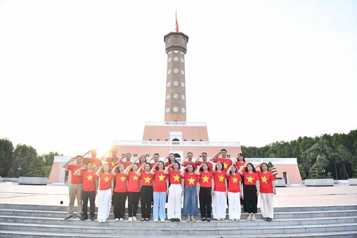 Tập thể Báo Kiểm toán thực hiện nghi thức chào cờ tại Cột cờ Hà Nội trong Khu du lịch Mũi Cà Mau.