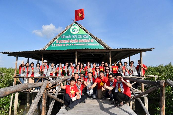 Đoàn công tác chụp ảnh lưu niệm dưới lá cờ Tổ quốc tung bay tại nơi cực Nam của đất nước...