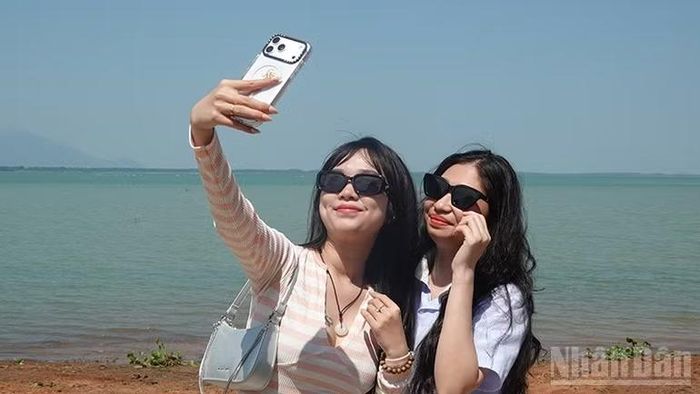 Du khách chụp ảnh tại hồ Dầu Tiếng.