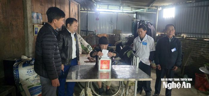 Cử tri Lầu Xo Cháy (SN1931), ở bản Ngã Ba, xã Huồi Tụ bầu cử tại nhà dưới sự hỗ trợ của Tổ bầu cử. Ảnh: P.V