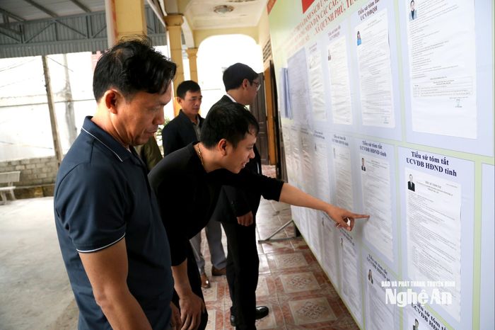 Cử tri theo dõi, tìm hiểu tiểu sử các ứng cử viên được niêm yết công khai tại khu vực bỏ phiếu trước ngày bầu cử. Ảnh: X.H