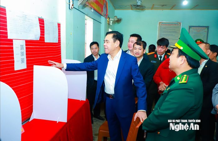 Chủ tịch UBND tỉnh Võ Trọng Hải trao đổi với tổ bầu cử tại điểm bỏ phiếu ở thôn Tiến Thành, xã Con Cuông. Ảnh: Thành Duy