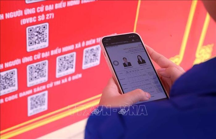 Cử tri quét mã QR bằng điện thoại thông minh nhanh chóng tra cứu các thông tin liên quan đến bầu cử. Ảnh: Văn Điệp/TTXVN