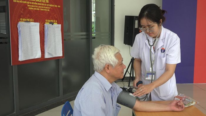Chị Phạm Minh Hằng, viên chức Trạm Y tế phường Xuân Đỉnh đo huyết áp cho bệnh nhân