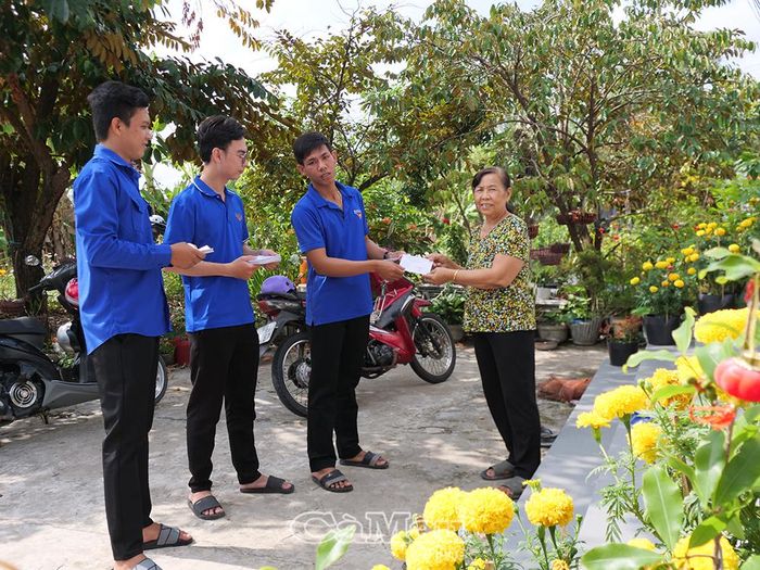 Đoàn viên, thanh niên hỗ trợ địa phương phát thẻ cử tri cho người dân.