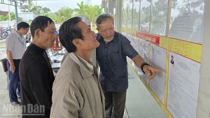 Cử tri xã Hòa Thịnh xem tiểu sử các ứng cử viên trước khi bỏ phiếu.