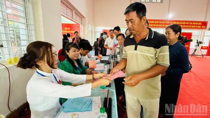 Cử tri nhận phiếu bầu. (Ảnh: VƯƠNG LÊ)