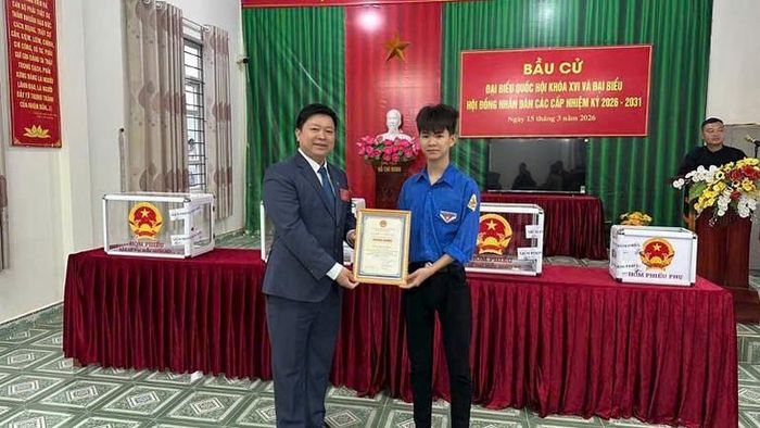 Lãnh đạo xã Quảng Tân trao giấy chứng nhận cho cử tri Dìn Tiến Long lần đầu tiên đi bầu cử.
