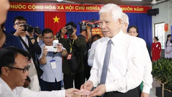 Nguyên Chủ tịch nước Nguyễn Minh Triết nhận phiếu bầu cử từ cán bộ Ủy ban bầu cử.
