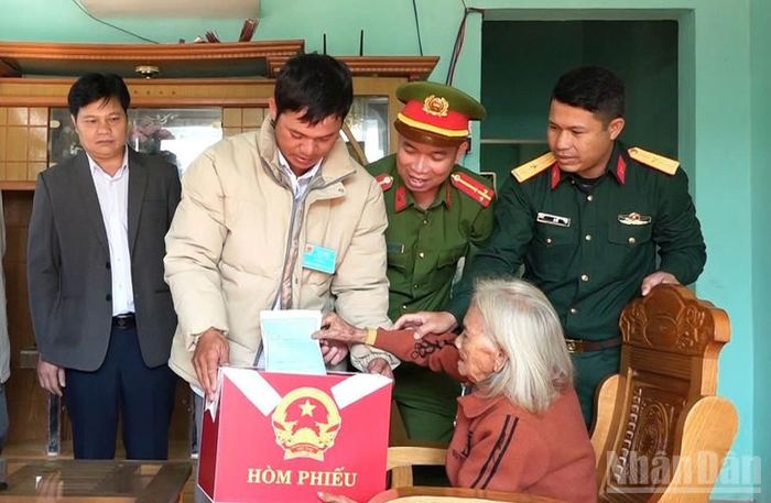 Tổ bầu cử ở xã Tu Mơ Rông mang thùng phiếu đến tận nhà để Mẹ Việt Nam Anh hùng Y Tría trực tiếp bỏ phiếu.