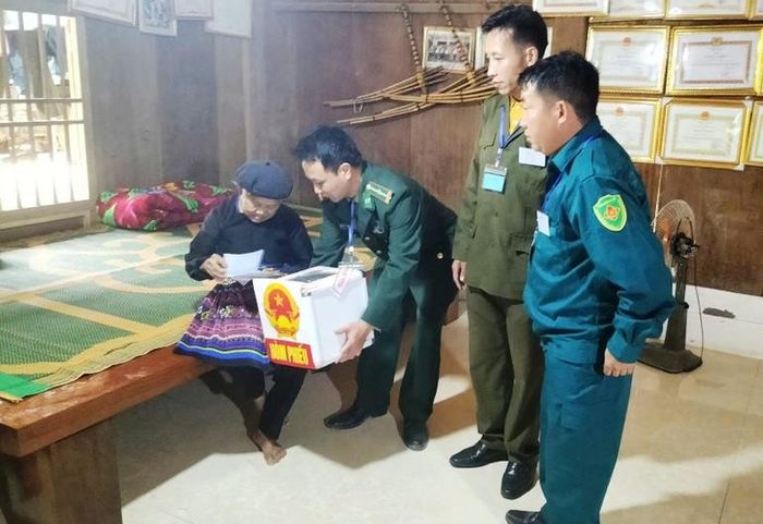 Các nhân viên Tổ bầu cử ở xã Trung Lý đem hòm phiếu phụ đến gia đình cho người cao tuổi bỏ phiếu.