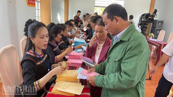 Cử tri khu vực bầu cử số 25 ở buôn Tuôr, xã Hòa Phú nhận phiếu bầu cử.