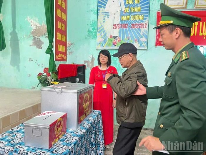 Bộ đội biên phòng tỉnh Hưng Yên hỗ trợ người già yếu đến địa điểm bỏ phiếu.