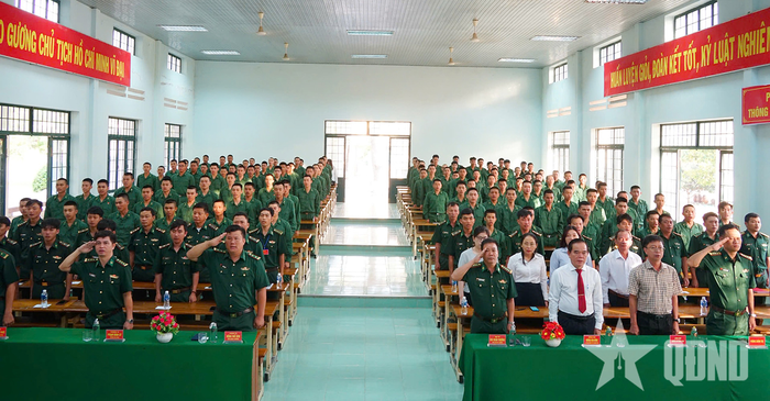 Cán bộ, chiến sĩ và nhân dân địa phương chào cờ trước giờ bỏ phiếu tại Tiểu đoàn Huấn luyện - Cơ động 2. 