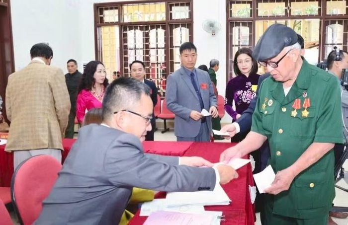 Các cử tri xã Mai Sơn nhận phiếu bầu.