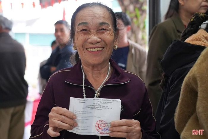 Cử tri phấn khởi cầm thẻ cử tri để bầu ĐBQH và đại biểu HĐND.