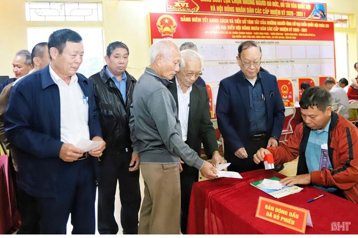 Thành viên tổ bầu cử đóng dấu vào thẻ cử tri sau khi cử tri hoàn thành bỏ phiếu.