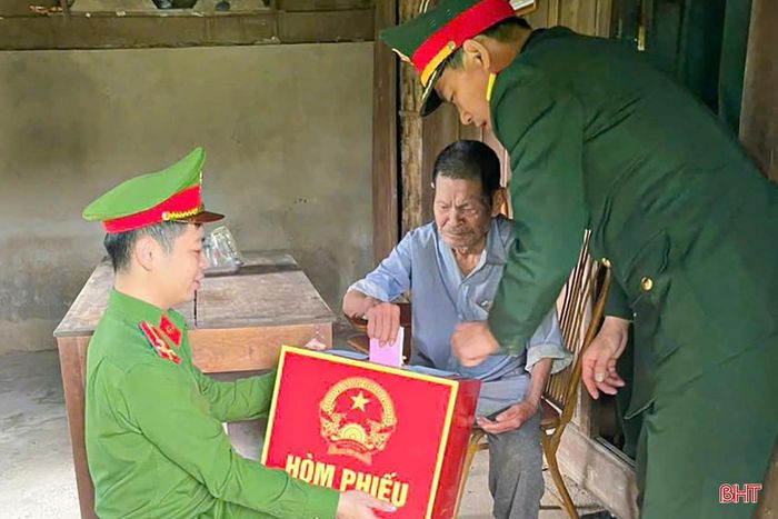 Thành viên tổ bầu cử ở xã Sơn Kim 1 mang hòm phiếu đến tận nhà, tạo điều kiện thuận lợi cho cử tri Lê Văn Tứ (SN 1936, trú thôn Vũng Tròn, là người dân tộc Mán, không đi lại được) tham gia bỏ phiếu.