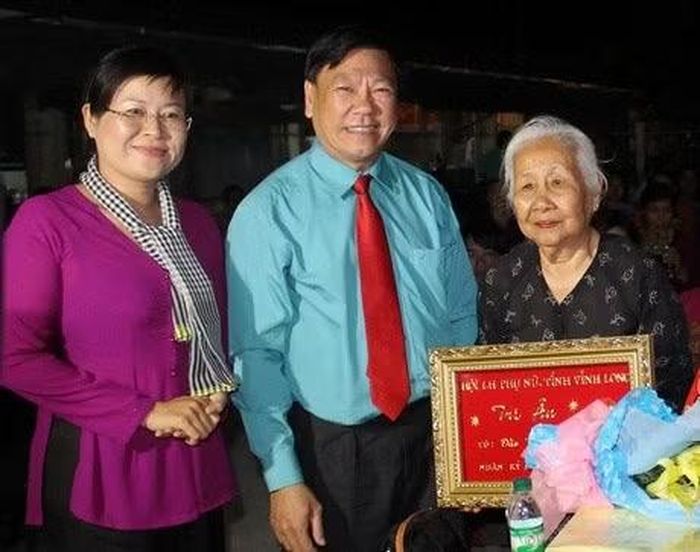 Nguyên Bí thư Tỉnh ủy Vĩnh Long Trần Văn Rón tặng hoa tri ân cho bà Đào Thị Biểu nhân dịp 8/3. (Ảnh: Báo Vĩnh Long)