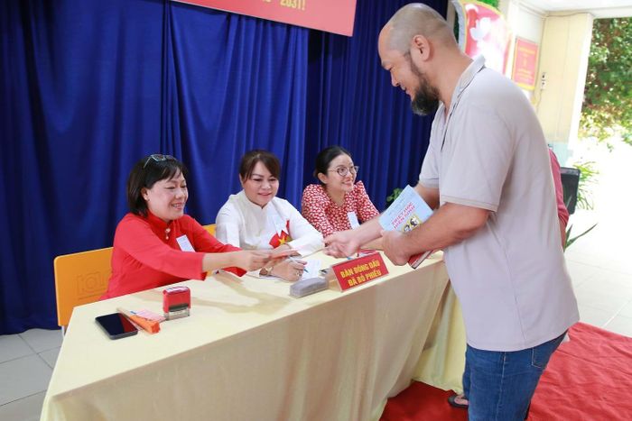 Thành viên Tổ bầu cử hướng dẫn cử tri thực hiện đúng quy trình bỏ phiếu tại Đơn vị bầu cử số 6 - Khu vực bỏ phiếu số 16.