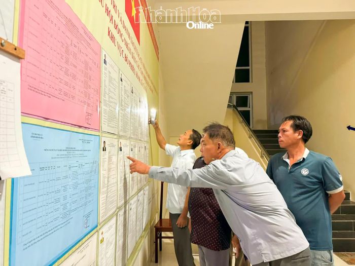 Cử tri tìm hiểu thông tin người ứng cử được niêm yết tại Khu vực bỏ phiếu số 6.