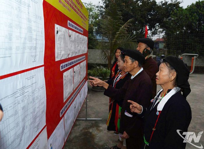 Cử tri là người dân tộc thiểu số tại xã Phúc Thuận nghiên cứu thông tin các ứng cử viên.