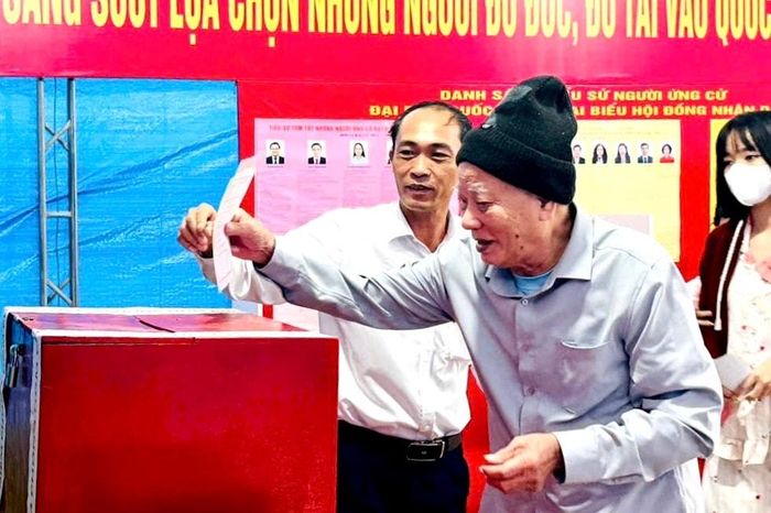 Cử tri cao tuổi ở xã An Lão sức khỏe yếu phải ngồi xe lăn, nhưng vẫn nhờ sự hỗ trợ của người thân để tự mình đi bỏ phiếu. Ảnh: Nguyễn Hạnh
