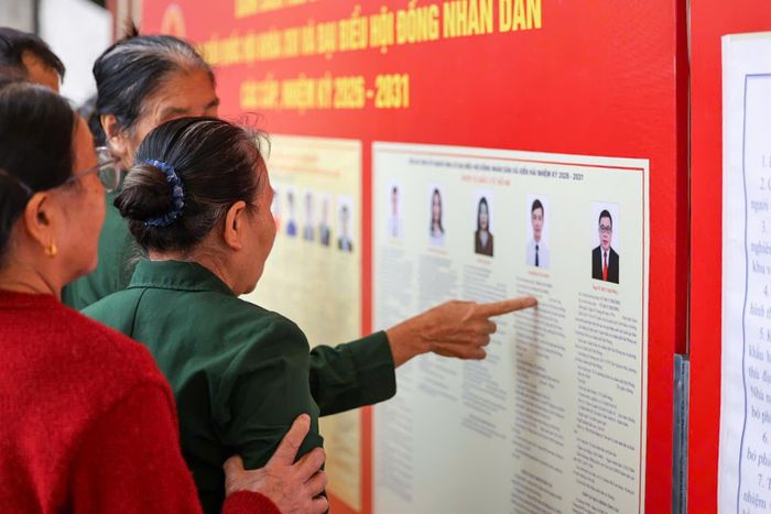 Cử tri nghiên cứu tiểu sử các ứng cử viên trước khi bỏ phiếu tại khu vực bầu cử. Ảnh: Đỗ Khắc Trường