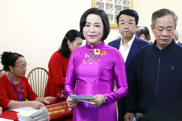 Phó Chủ tịch Quốc hội Nguyễn Thị Thanh và các cử tri thực hiện nhận phiếu bầu cử trước khi bỏ phiếu tại khu vực bỏ phiếu số 27, phường Hoa Lư