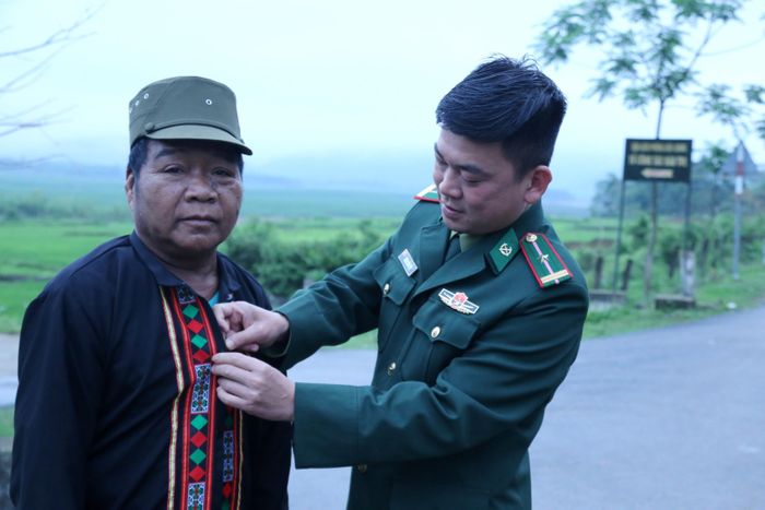 Cán bộ Tổ công tác Biên phòng bản Rào Tre sửa lại áo cho bà con trước khi đi bầu cử
