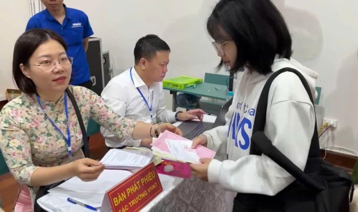 Cử tri Lê Thị Tú nhận phiếu bầu cử tại khu vực bầu cử số 23 phường Phú Diễn, Hà Nội sáng 15/3
