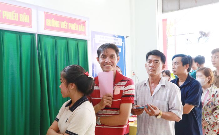 Dù phải xếp hàng dài nhưng cử tri rất vui vẻ, phấn khởi khi tự mình bầu chọn ra những đại biểu ưu tú. Ảnh: Văn Dũng