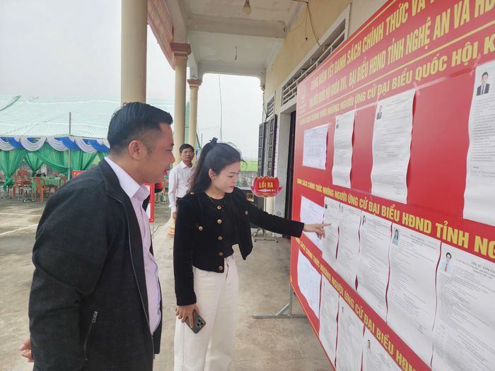 Chủ tịch Hội đồng phục vụ giáo họ độc lập Nho Lâm Nguyễn Văn Đương và cử tri Trần Thị Hiền tìm hiểu thông tin về các cử tri.