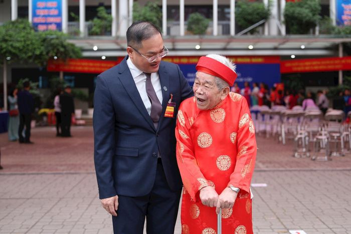Đồng chí Nguyễn Ngọc Việt, Bí thư Đảng ủy phường chia vui với cụ Bùi Văn Tài (91 tuổi) sau khi bầu cử. Ảnh: Hoa Thành