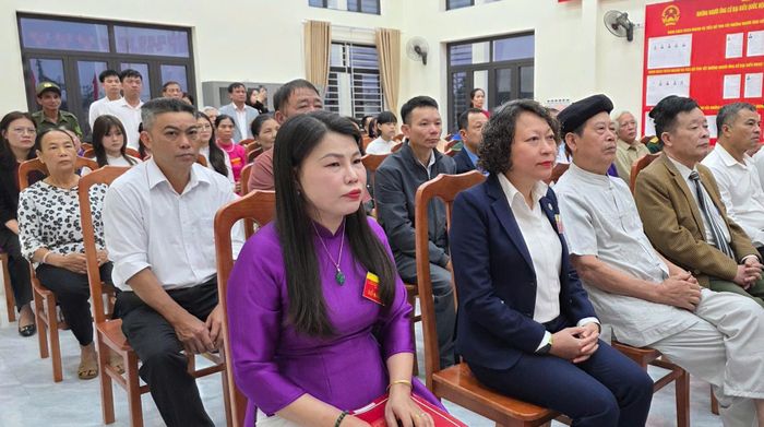 Các đại biểu và cử tri chào cờ tại lễ khai mạc sớm tại Khu vực bỏ phiếu số 1 (thôn Hát Môn 1). Ảnh: Hoàng Thoàn
