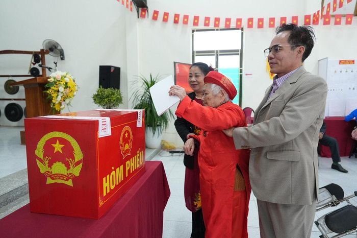 Cụ Lưu Thị Dậu (103 tuổi) được con cháu đưa đến tham gia bầu cử. Ảnh: Nguyễn Trọng