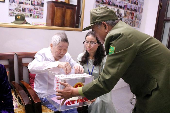 Tổ bầu cử mang hòm lưu động tới nhà các cử tri cao tuổi, khó khăn đi lại để các cụ trực tiếp bỏ phiếu. Ảnh: Lê Thắm
