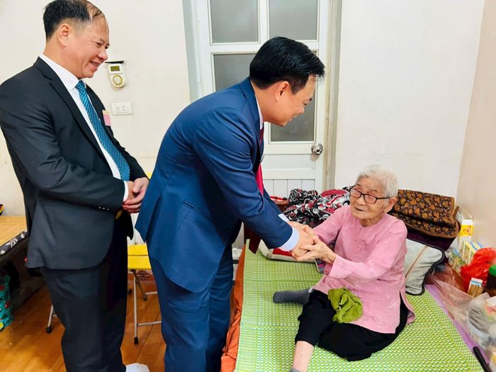 Chủ tịch UBND xã Tam Hưng Bùi Đình Thái động viên cụ Thái Thị Tha, 102 tuổi, cử tri cao tuổi nhất thôn Song Khê. Ảnh: Ánh Ngọc 