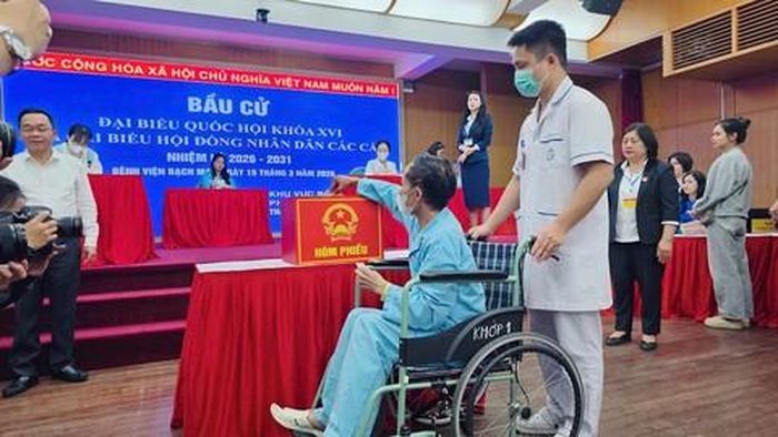 Bệnh nhân Bệnh viện Bạch Mai (Hà Nội) được nhân viên y tế hỗ trợ thực hiện quyền bầu cử tại điểm bỏ phiếu lưu động
