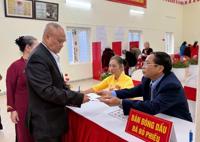 Tổ bầu cử đóng dấu thẻ cử tri xác nhận đã bỏ phiếu. Ảnh: NC